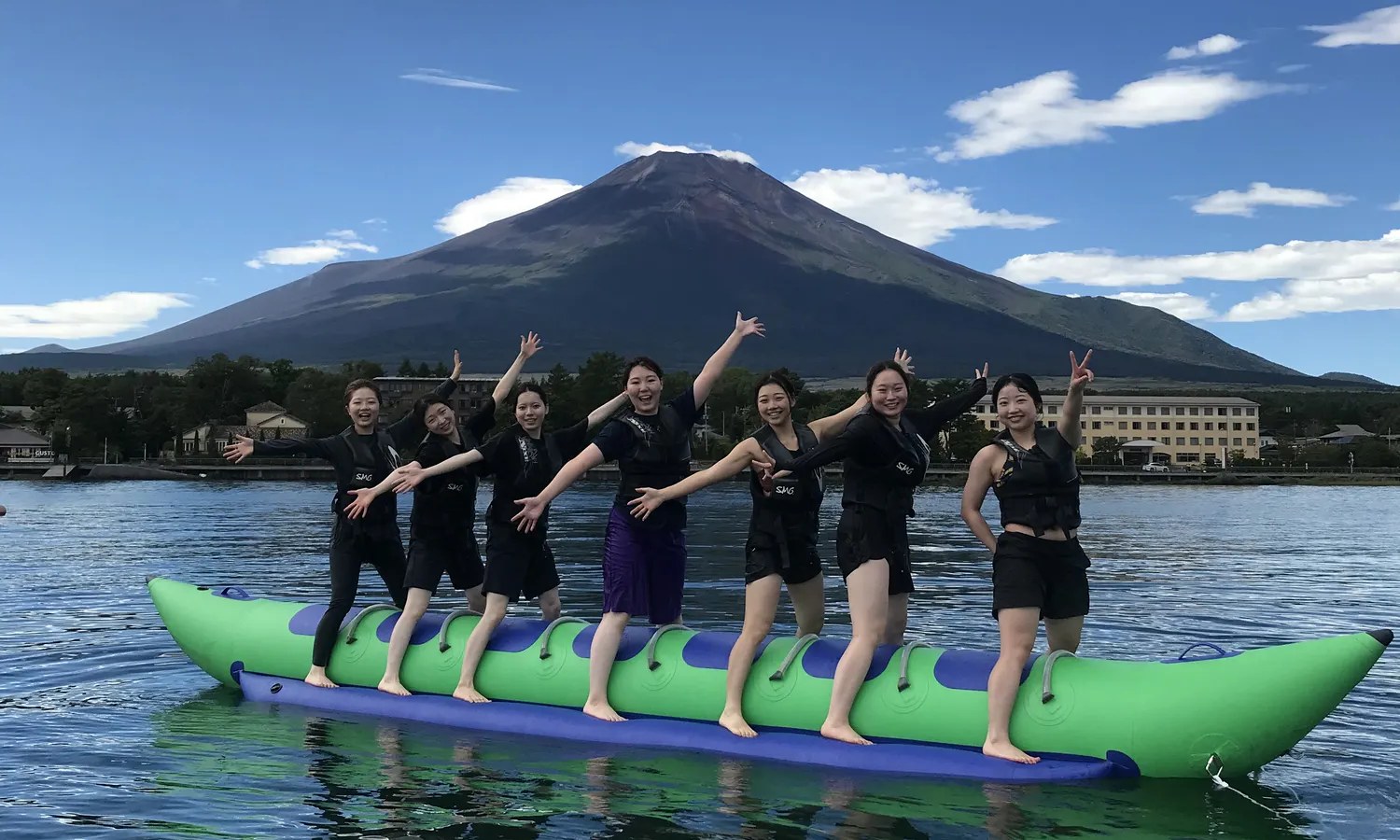 山中湖でバナナボートを楽しむグループと富士山